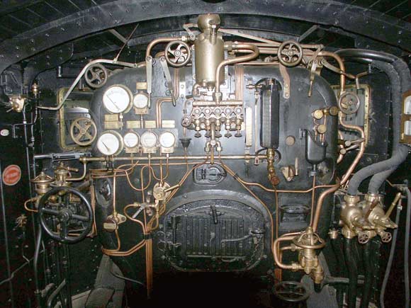 This is the cab of 230B114. An interesting feature of PLM locos is the spy hole above the firehole door allowing the condition of the fire to be ascertained. This system has the advantage of not having to open the firehole door and thus disturb the air flow. However just how much use this spy hole would be in service is debatable. Examining the fire on the move often requires the firehole door to be open and the use of the shovel to manipulate the airflow before all parts of the fire can be seen. October 9 2003